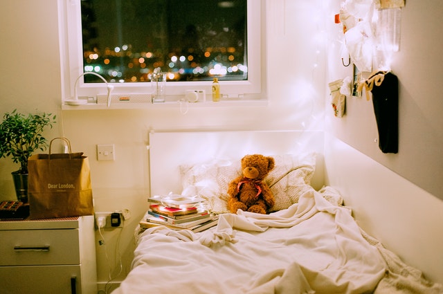 Posteľ v detskej izbe s plyšovými medveďmi a svetielkami